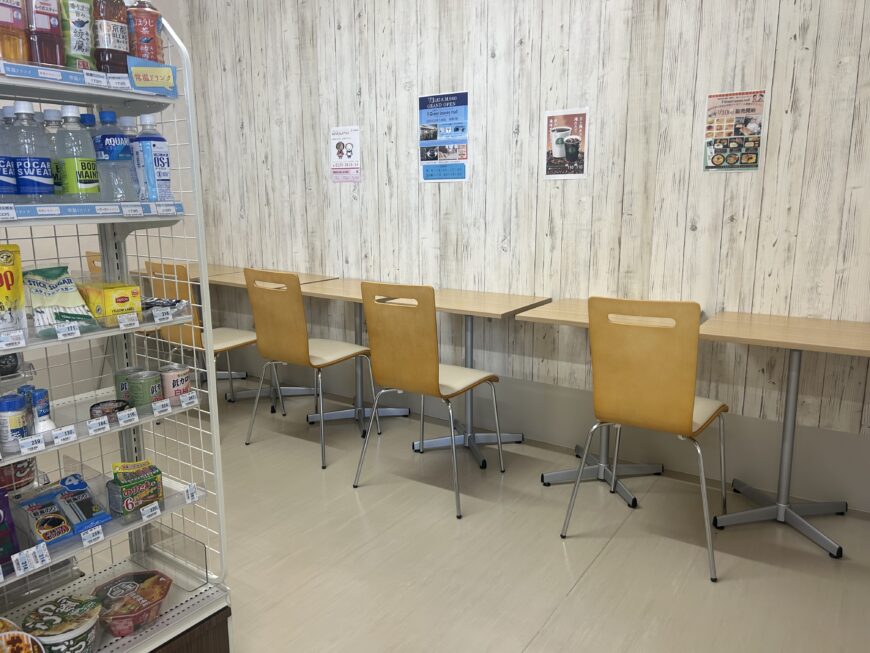 待合スペース。木目調の壁面、掲示板、販売棚、待機用の椅子が配置されている。
